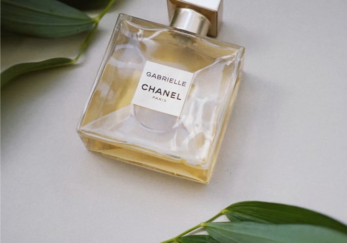 A small glass perfume bottle of Chanel Gabrielle Paris with gold contents